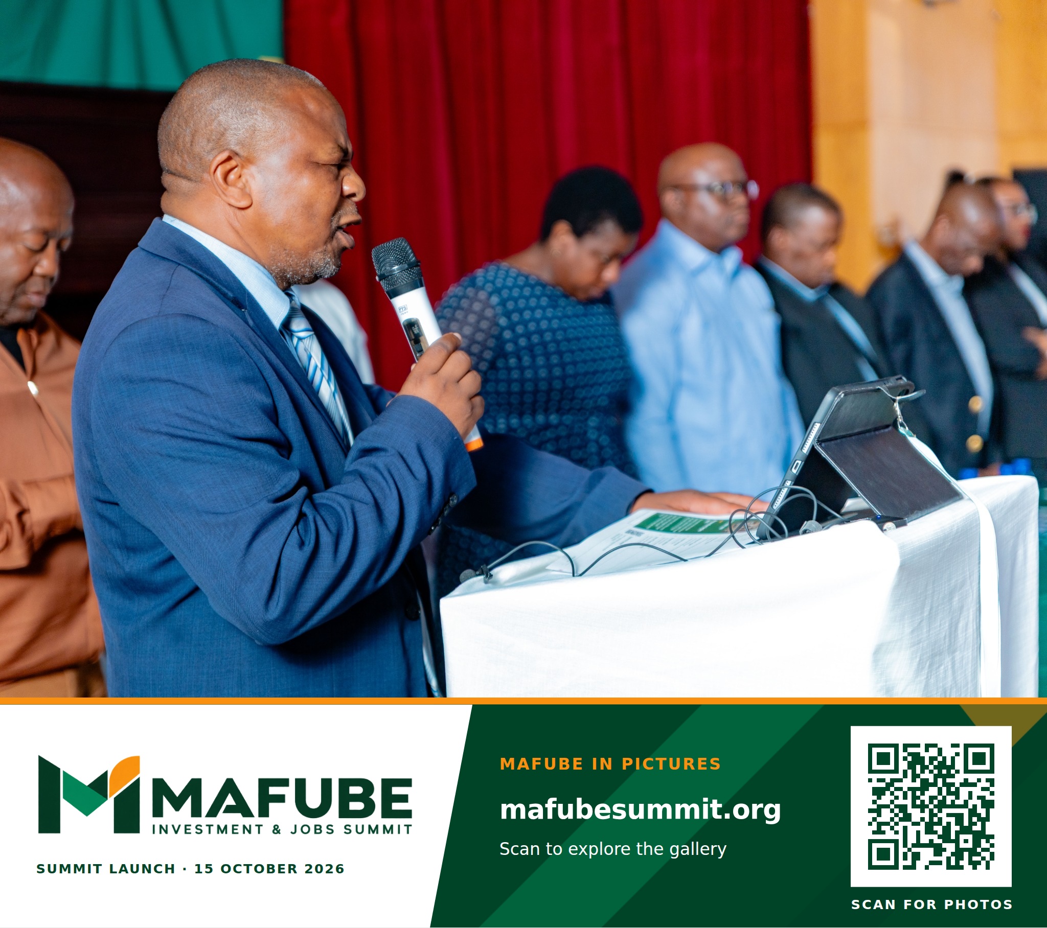 A speaker addresses the hall from the podium, with the Mafube Investment & Jobs Summit photo footer