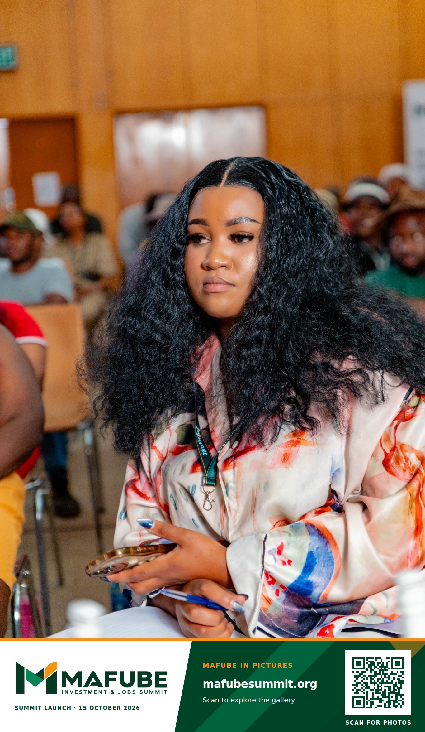 A participant listens in the audience, with the Mafube Investment & Jobs Summit photo footer